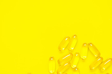 Fototapeta na wymiar Omega 3 fish oil capsules on yellow background. Concept of healthcare. Top view, flat lay, copy space.