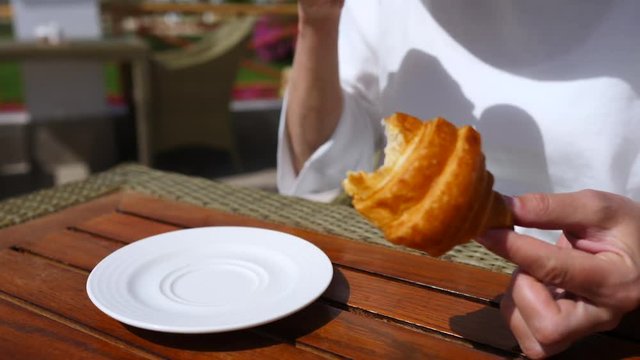 Woman Drinking Coffee With Croissant In Cafe. Closeup.