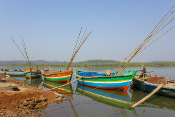 Fototapeta premium new colorful Indian boats with fishing rods anchored off the coast against the backdrop of the river