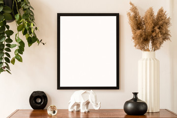 Minimalistic and stylish mock up poster frame concept with retro furnitures, hanging plant, flowers in vase and elegant accessories. White walls, home decor. Nice interior of living room. Real photo.