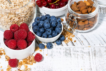 fresh blueberries, raspberries and breakfast products on white table, top view