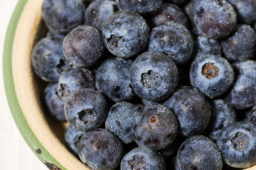 fresh juicy blueberries in a bowl on white background, top view closeup