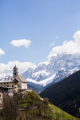 Beautiful mountain scenery in the Alps with fresh green meadows in bloom on a beautiful sunny day in springtime. Dolomiti montains in Italy. Landscape in spring in Europe. 