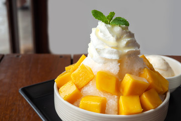 Shaved ice dessert with mango sliced.  Served with vanilla ice cream and whipped cream. Sweet dessert in Korean style. Local name, Bingsu.