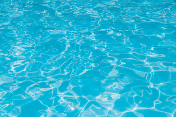 Pattern of blue water surface in swimming pool, Ripple wave and motion water for blue background and abstract, Bright and purified water with sun reflection in pool