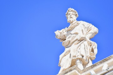 Fototapeta na wymiar Ancient Saint Statue on Top of Bernini's Colonnade in Vatican City