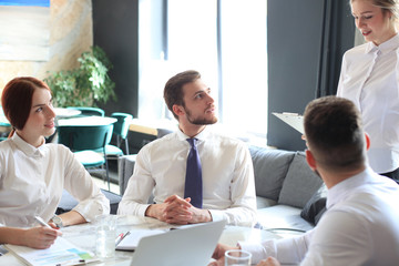 Group of business partners discussing ideas and planning work in office.