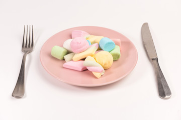Plate with marshmallow, fork, knife  isolated on white background.