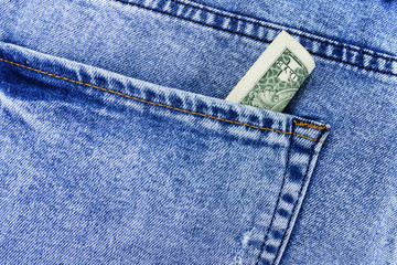 dollar bill sticking out from a blue jean pocket