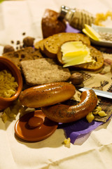 Whole grain bread put on kitchen wood plate. Fresh bread. Fresh bread on the kitchen table The healthy eating and traditional bakery concept. and whole grains of wheat and rye, butter and bagels