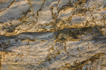 gray yellow rock with very deep relief, cracks and shadows. natural surface texture