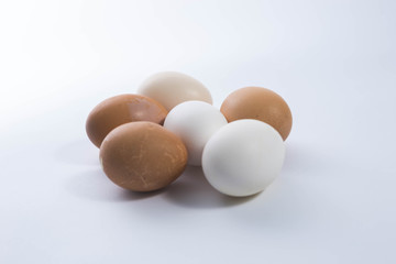 White and brown eggs on white background