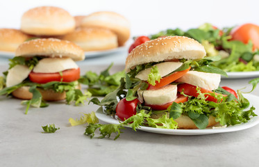 Sandwich with mozzarella, tomato and salad on the kitchen table.