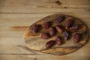 dates on a wooden board, wooden natural background with copy space for text. Top view. Flat lay. Healthy food.