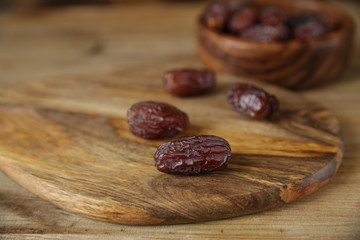 royal dates in a wooden plate, on a wooden natural background, closeup
