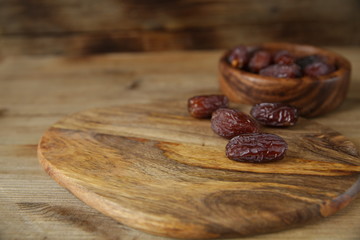 royal dates in a wooden plate, on a wooden natural background, closeup