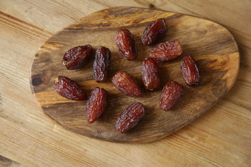 royal dates on a wooden board, wooden natural background, closeup. Top view. Flat lay. Healthy food.