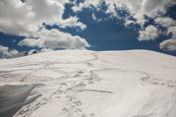 Beautiful winter landscape with snow in Alps. Dolomites. Panorama of snow mountain landscape with blue sky. Sunshine. Peaks. Rocks. Alps. Italy.