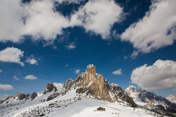 Beautiful winter landscape with snow in Alps. Dolomites. Panorama of snow mountain landscape with blue sky. Sunshine. Peaks. Rocks. Alps. Italy.