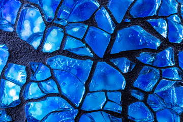 Abstract blue background - small glass, artistic glass processing. Beautiful deep color close to indigo. Creative glass cracks.