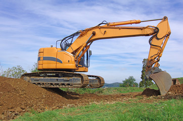 Excavator machine in action during earth moving works. Excavator, earthworks, house construction