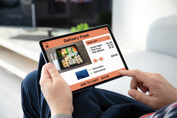 man hands holding computer tablet with app delivery food