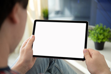 man hands holding computer tablet with isolated screen in room