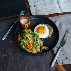 Beefsteak with egg and salad from greens and vegetables