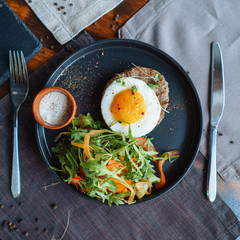 Beefsteak with egg and salad from greens and vegetables