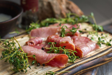 Delicious flavorful ham sliced ​​into strips on a wooden background with spices and fresh thyme. A serving of low-fat succulent farm meat pork. meat product. Food Photography