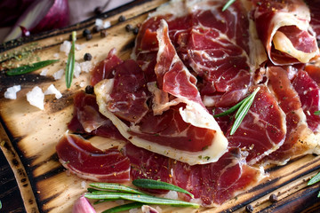 Hamon.Tasty ham sliced ​​into strips on a wooden background with spices and fresh thyme. A serving of lean pork. meat product. Food Photography . View from above