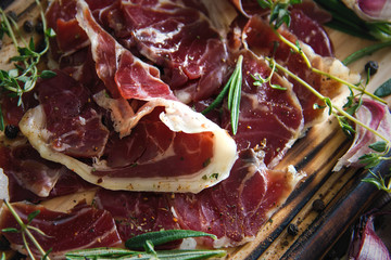 Hamon.Tasty ham sliced ​​into strips on a wooden background with spices and fresh thyme. A serving of lean pork. meat product. Food Photography . View from above