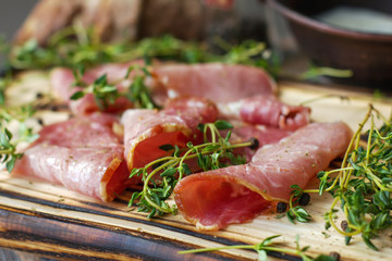 Delicious flavorful ham sliced ​​into strips on a wooden background with spices and fresh thyme. A serving of low-fat succulent farm meat pork. meat product. Food Photography