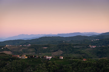 Fototapeta premium Sunrise over vineyard hills from village Vedrijan and Julian Alps