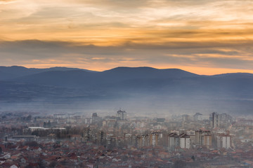 Fototapeta na wymiar Stunning, soft view of golden sunset sky above scenic cityscape covered by haze and mist