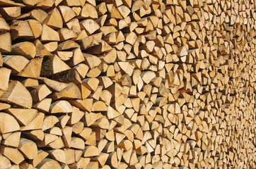 Stacked wood background. Freshly cut and stacked wood logs. Renewable energy