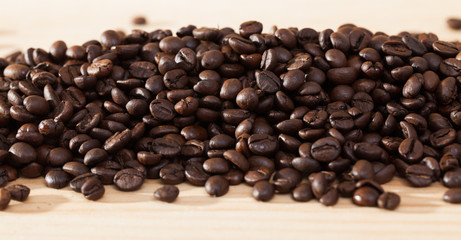 Coffee beans on light wood surface