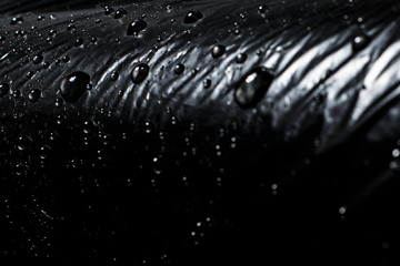 Water drops on a black background. Black polyethylene. Imitation black eco-leather.