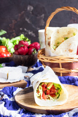 Fresh tortilla wraps with roasted chicken and vegetables, fresh juices, various vegetables and berries, fresh baguette and cheese. Ideas for picnic.