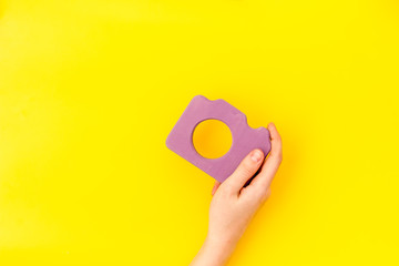 photo camera concept with hand on yellow background top view mock up