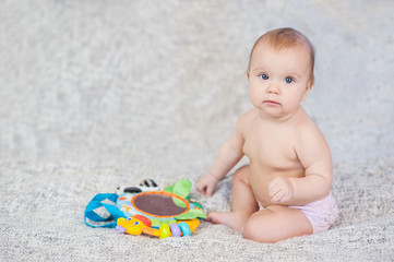 baby lying on Developing rug. playing in Mobile. educational toys. Sweet child Crawling And Playing With Toys On Carpet