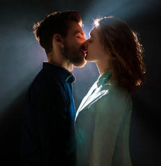 portrait photo of a sexy young couple in pre kiss in streams of light