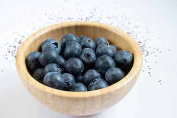 Bamboo bowl with blueberries. Decorated with chia seeds. 