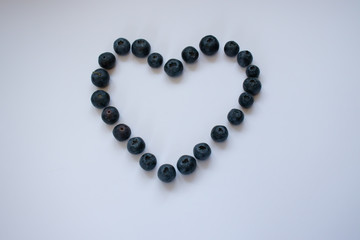 Blueberries laid out in the shape of a heart isolated on white