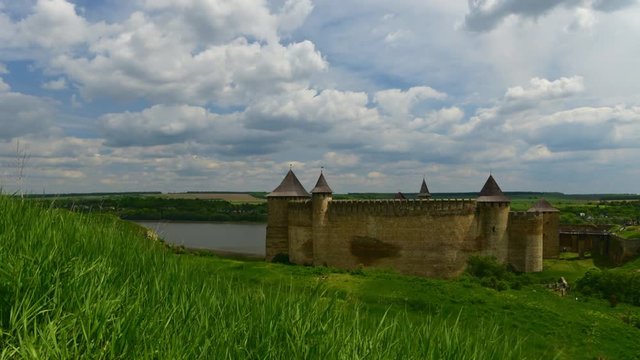 Timelapse of spring castle - wind moving clouds and green grass with old historical fortess