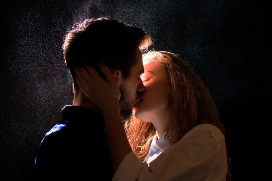 portrait photo of a sexy young couple in a pre kiss under water drops