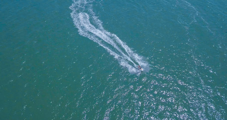 People are playing a jet ski in the sea. Aerial view.