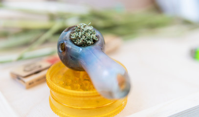 glass pipe for smoking marijuana. A man holds in his hand a tube with marijuana buds before use