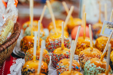 Apples in caramel and sprinkles. Street food.