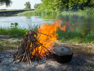 Campfire and cauldron near the river